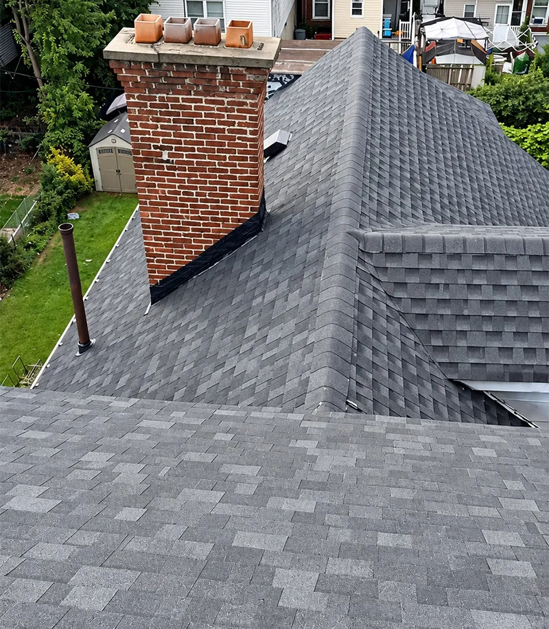 Damaged chimney flashing and asphalt shingles showing potential roof leak problems in Passaic County NJ