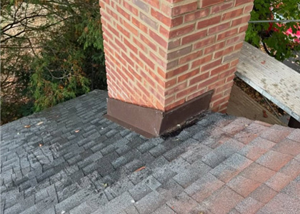 Chimney flashing restoration around a brick chimney and asphalt shingle roof