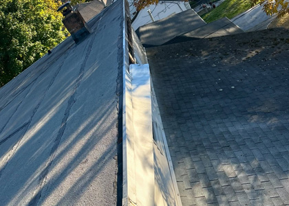 Wind-damaged asphalt shingles repaired on a residential roofing system